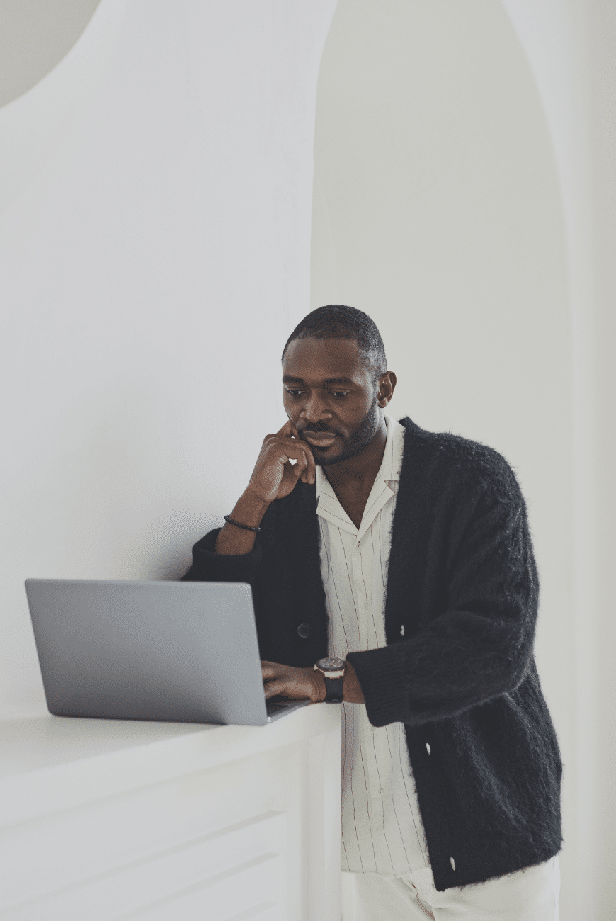 41 » admin by request A standing man resting his head on his hand while using his laptop. » admin by request